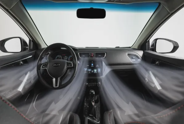 Vista degli interni dell'auto dal sedile posteriore, che mostra il cruscotto nero, il volante e la console centrale.