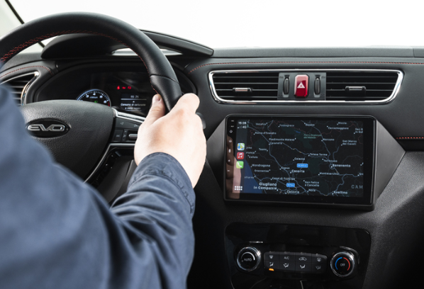 Conducente che utilizza il sistema di navigazione touchscreen del cruscotto dell'auto durante la guida