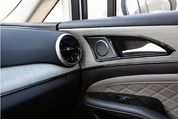Interni di auto di lusso con portiere e cruscotto dotati di bocchette d'aria circolari e rivestimenti in pelle trapuntata.