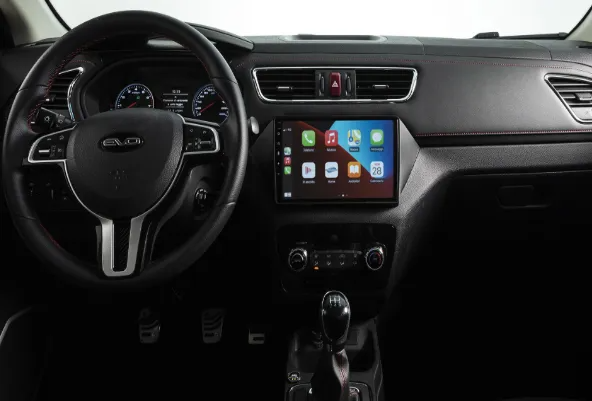 Cruscotto dell'auto con volante e touchscreen che mostra le icone delle app; console centrale e comandi visibili