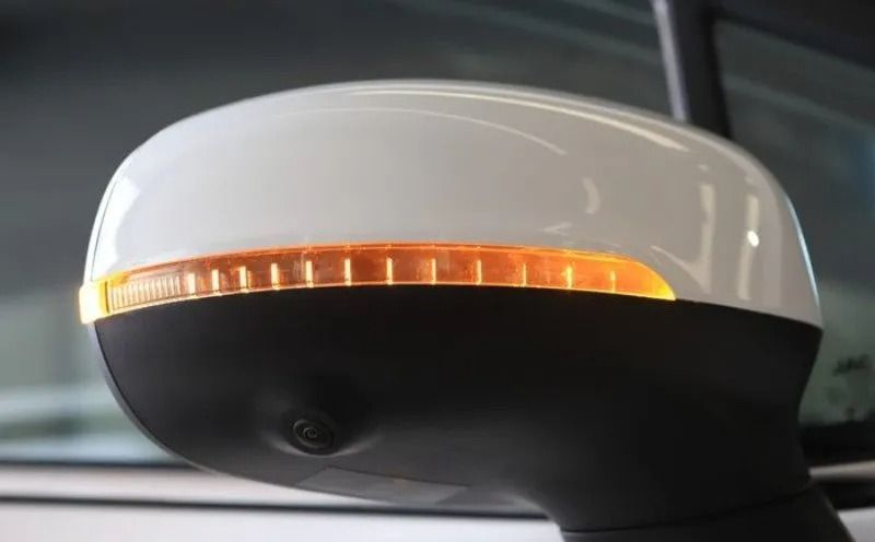 Faro da tetto bianco e nero con una striscia luminosa arancione, probabilmente di un taxi o di un lampeggiante di emergenza.