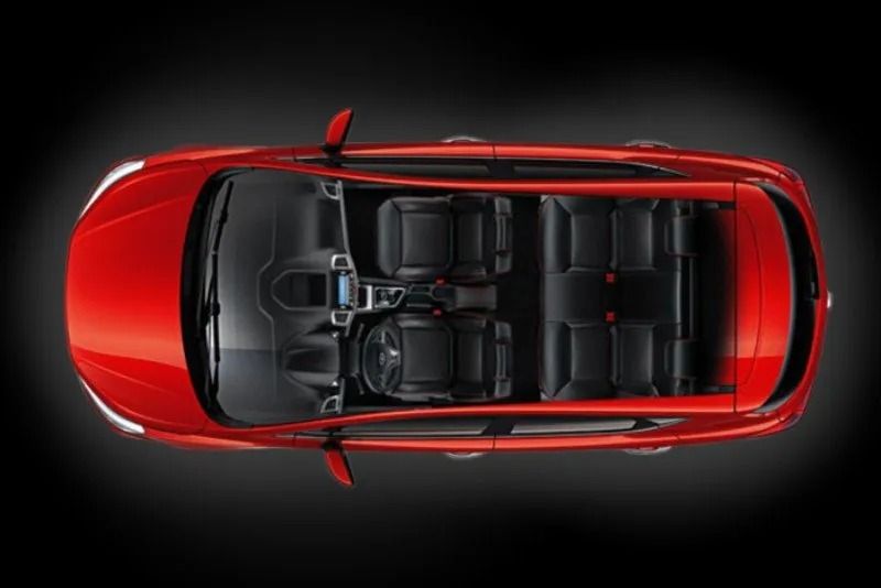 Vista dall'alto di un'auto rossa con interni neri e sedili su sfondo scuro.