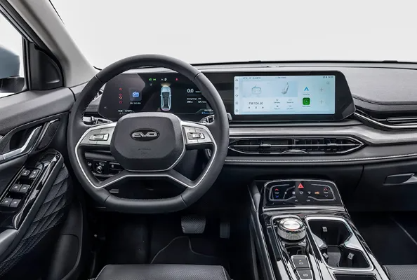 Interni moderni dell'auto con cruscotto digitale, ampio touchscreen e console centrale.