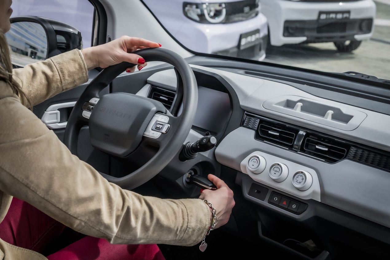 Il conducente regola il volante e i comandi all'interno dell'abitacolo di un'auto moderna.