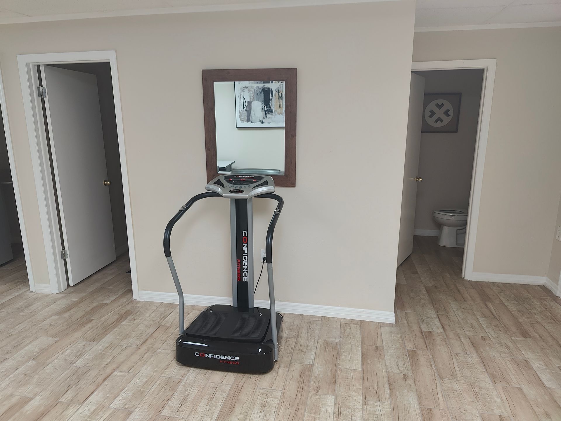 A vibration machine is sitting in a room next to a mirror.