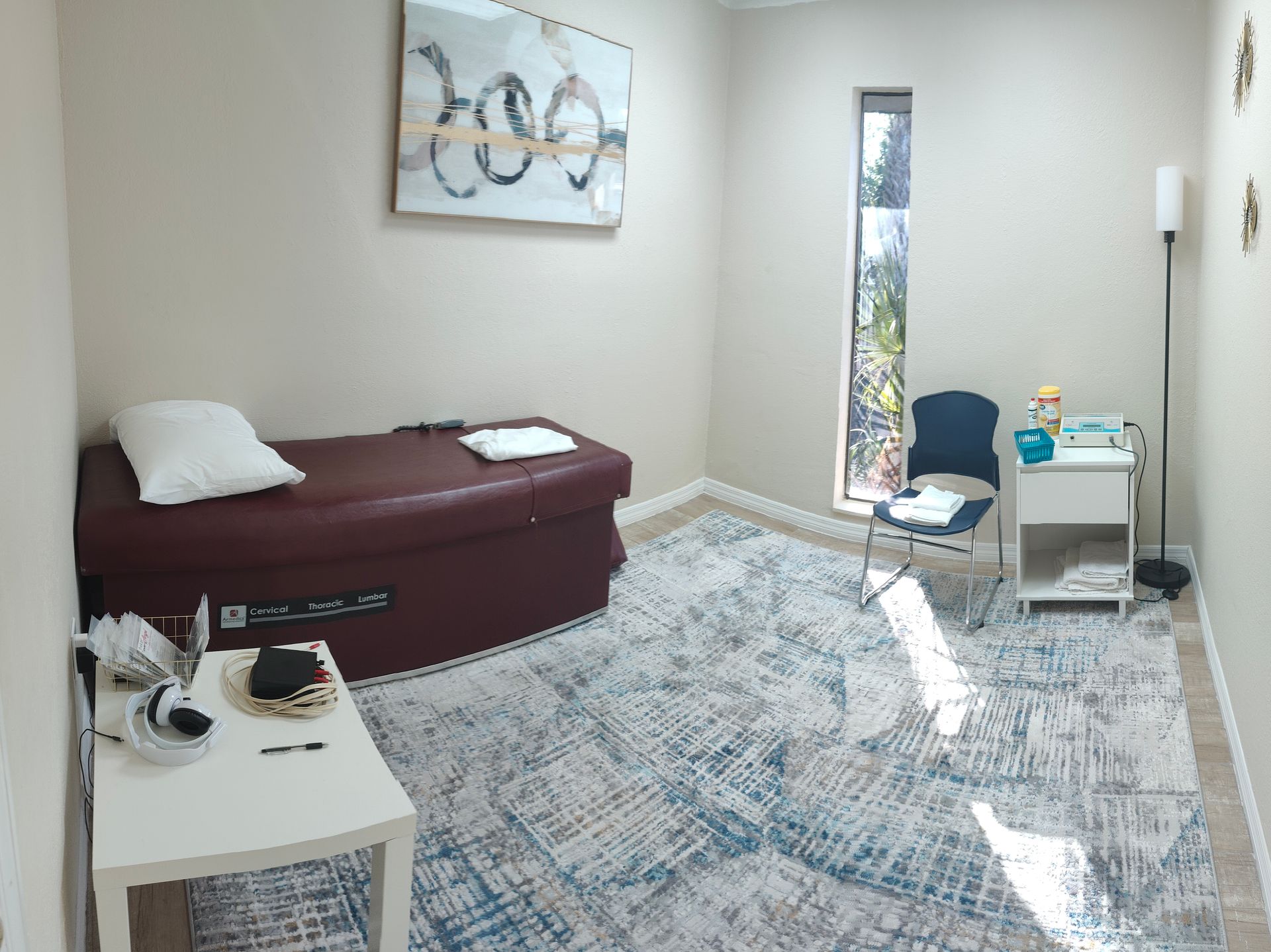 A room with a bed , chair , table and window.
