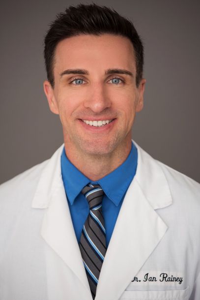 A man wearing a white lab coat and a blue shirt and tie