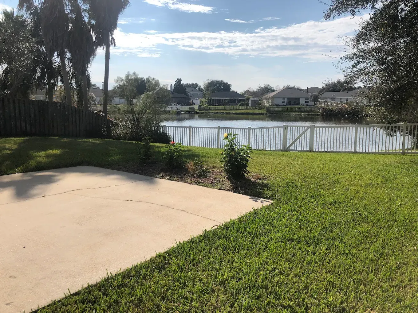 A view of a lake from the backyard of a house