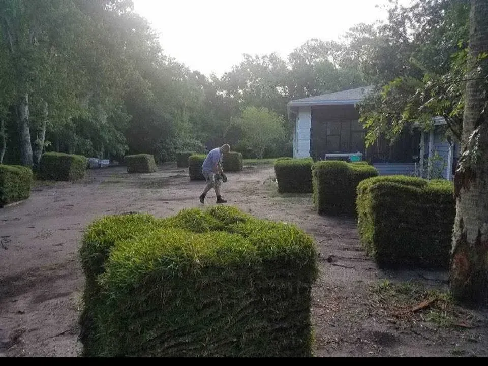 A man is standing on top of a pile of hay.