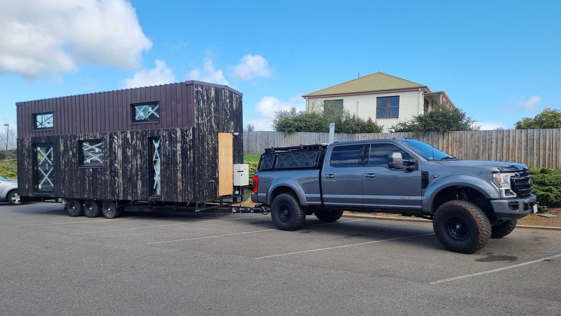 A truck is towing a tiny house on a trailer.