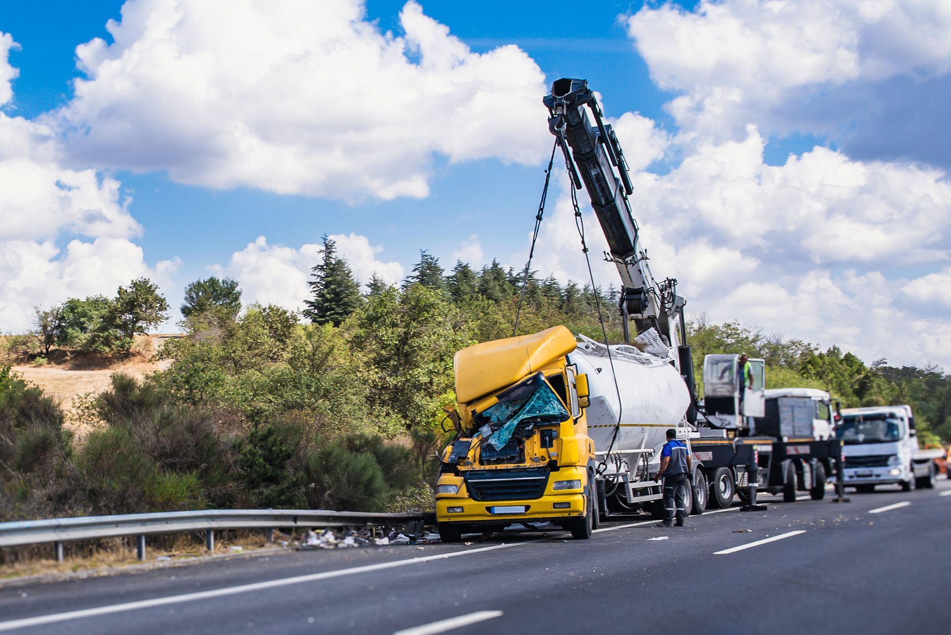 A recovery of a crashed yellow truck with a crane for heavy-duty vehicle accident recovery towing.