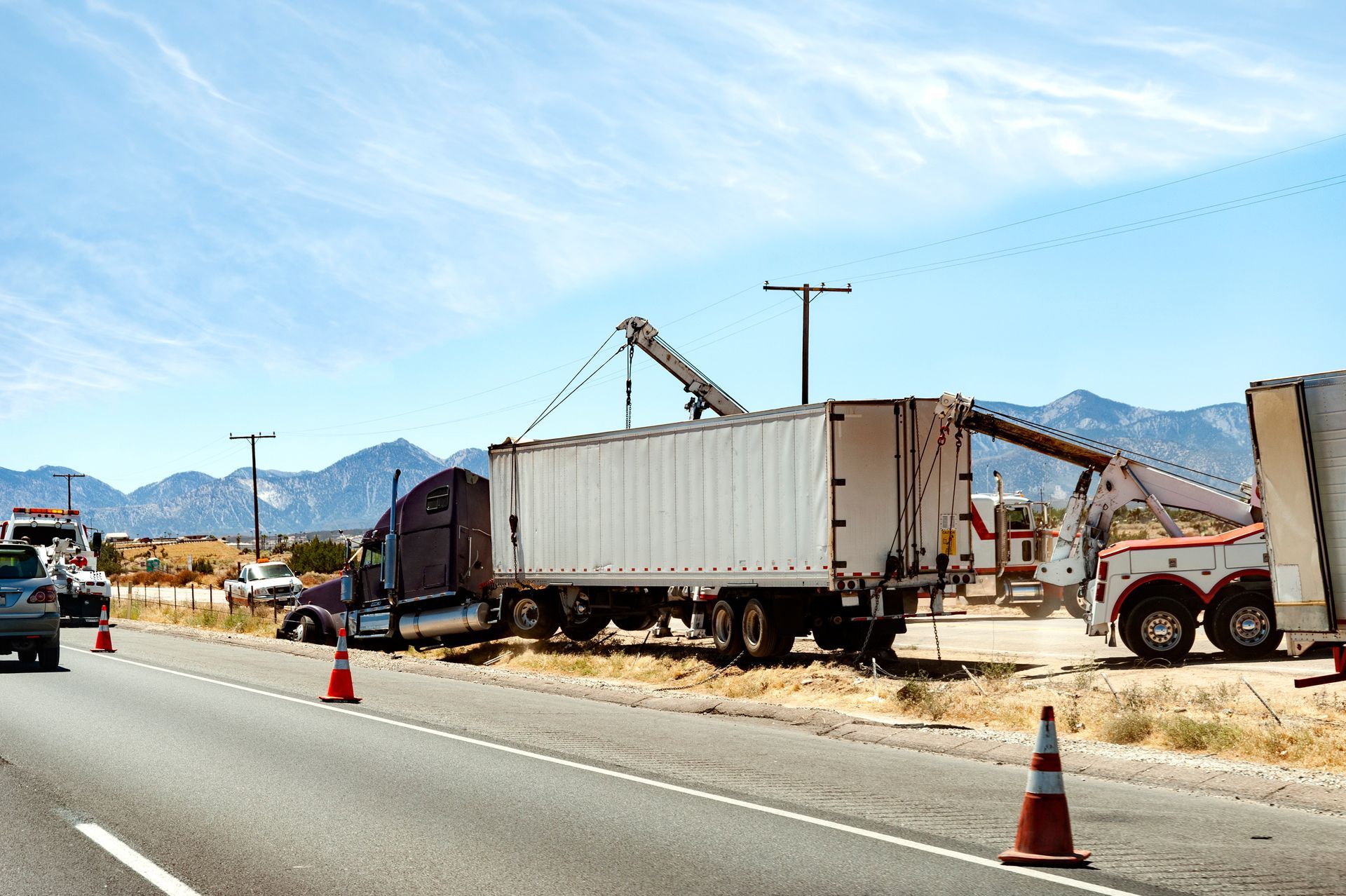 Removing a semi-truck and trailer from a ditch with a tow truck.