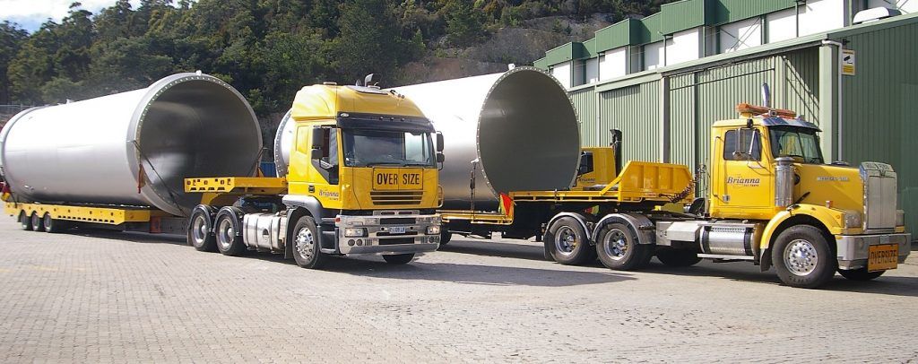 24/7 truck recovery hauling large cylindrical loads.