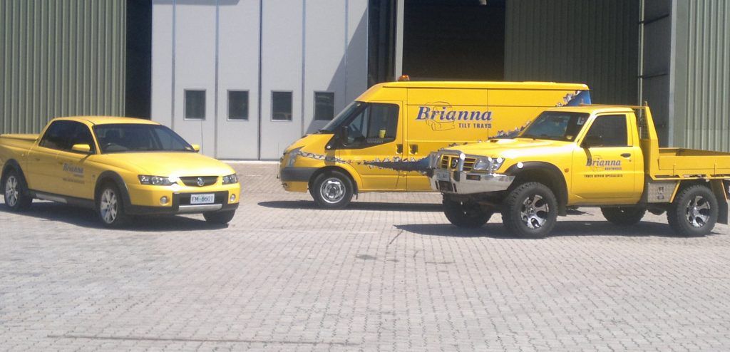 Towing support vehicles parked outside service building.