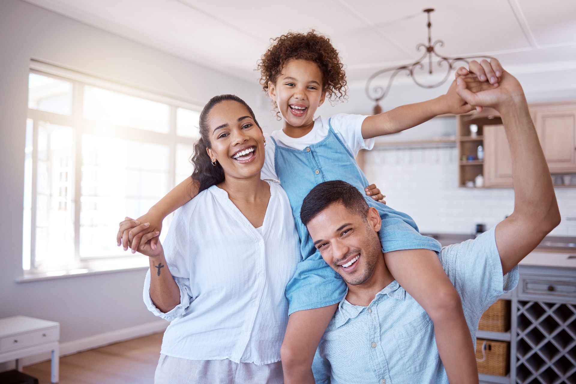Family relaxing on a couch, looking at a tablet together in a cozy living room.