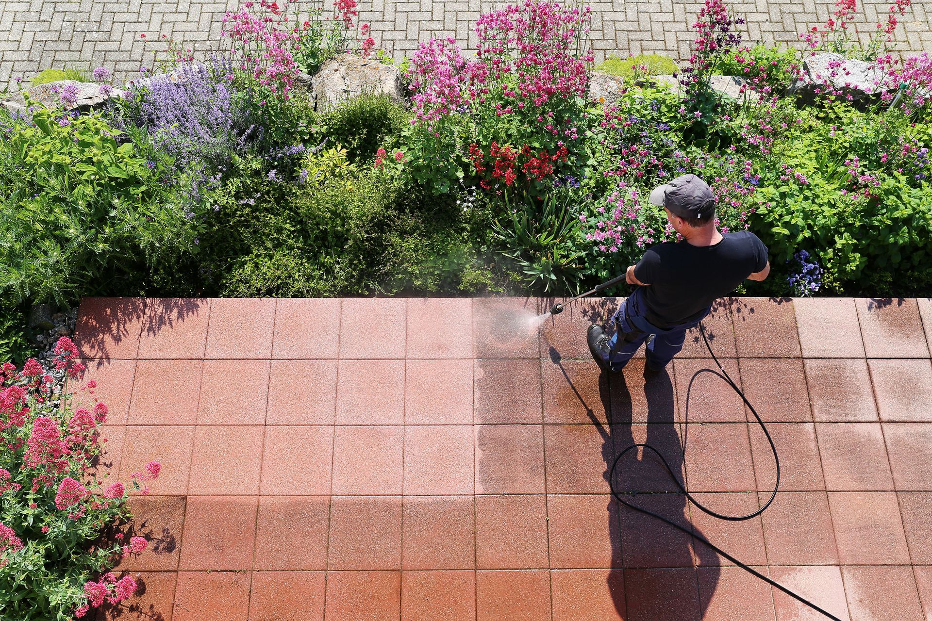 HomeSHINE technician power washing exterior pavers at Burlington home for our Shine Protection Plan.