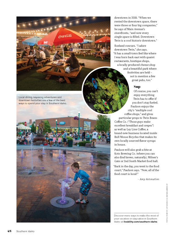 A boy is playing in a fountain in a park.