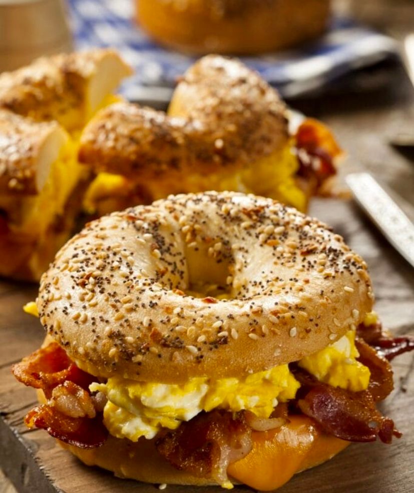 A bagel with eggs , bacon and cheese on it