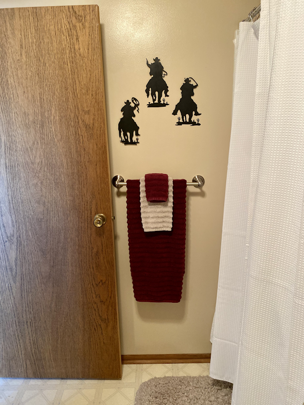 A red towel hangs on a towel rack in a bathroom