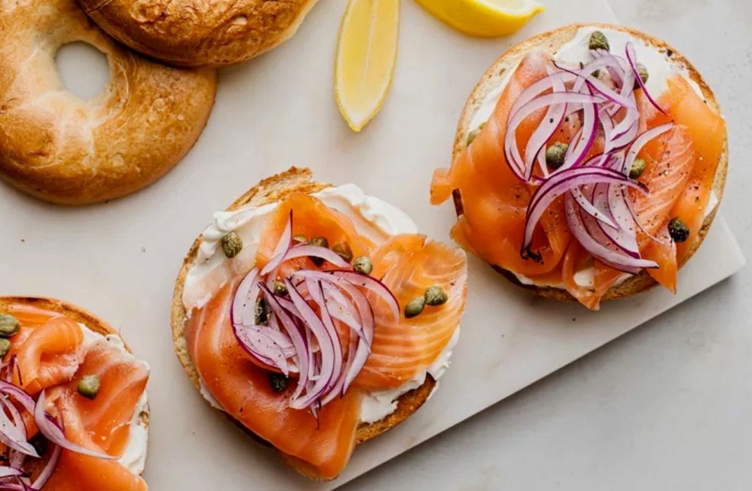 Bagels with cream cheese, smoked salmon, red onion, and capers.