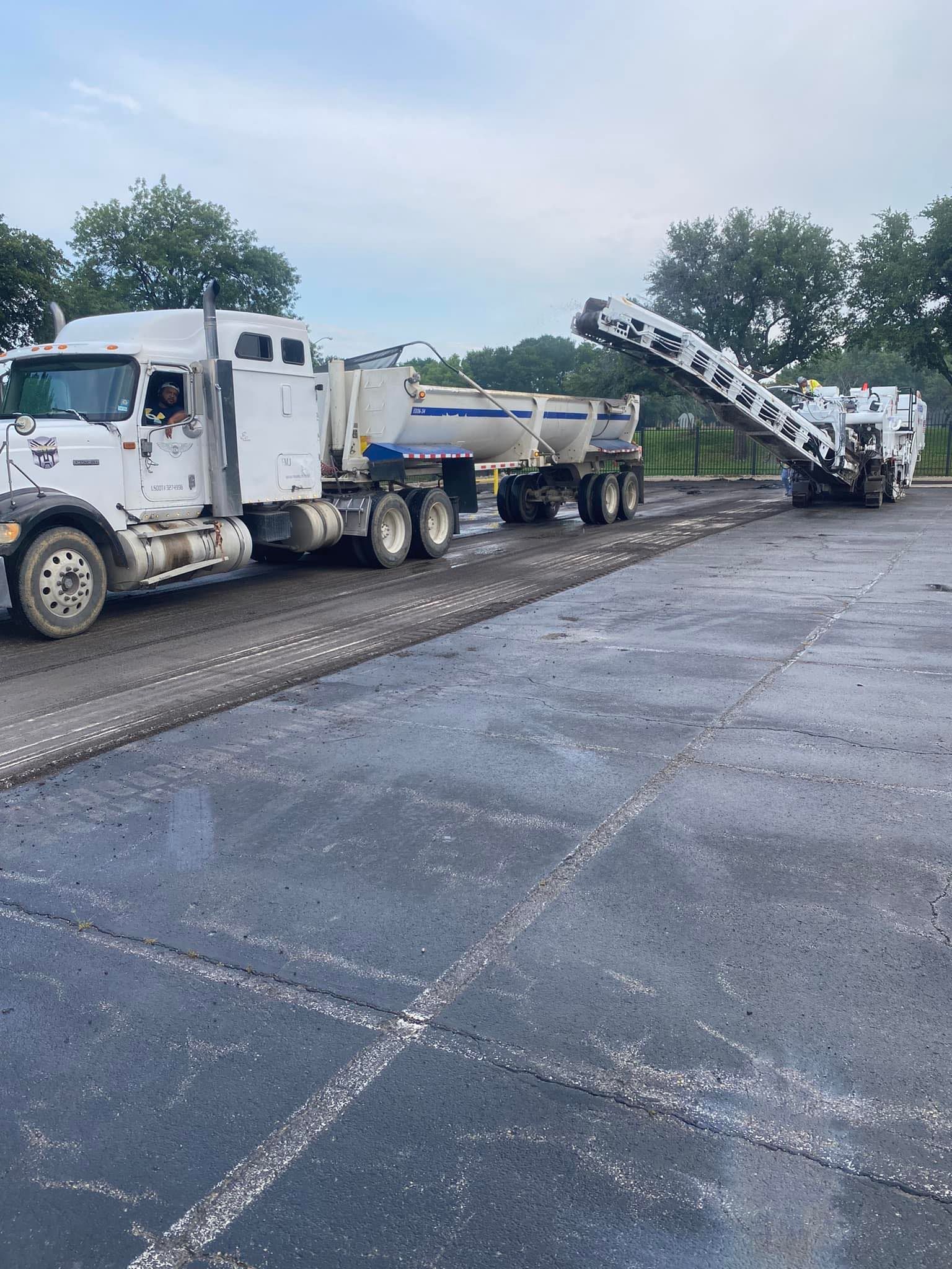 A truck is parked in a parking lot next to a machine.