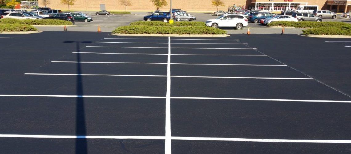 A parking lot with cars parked in it in front of a building.