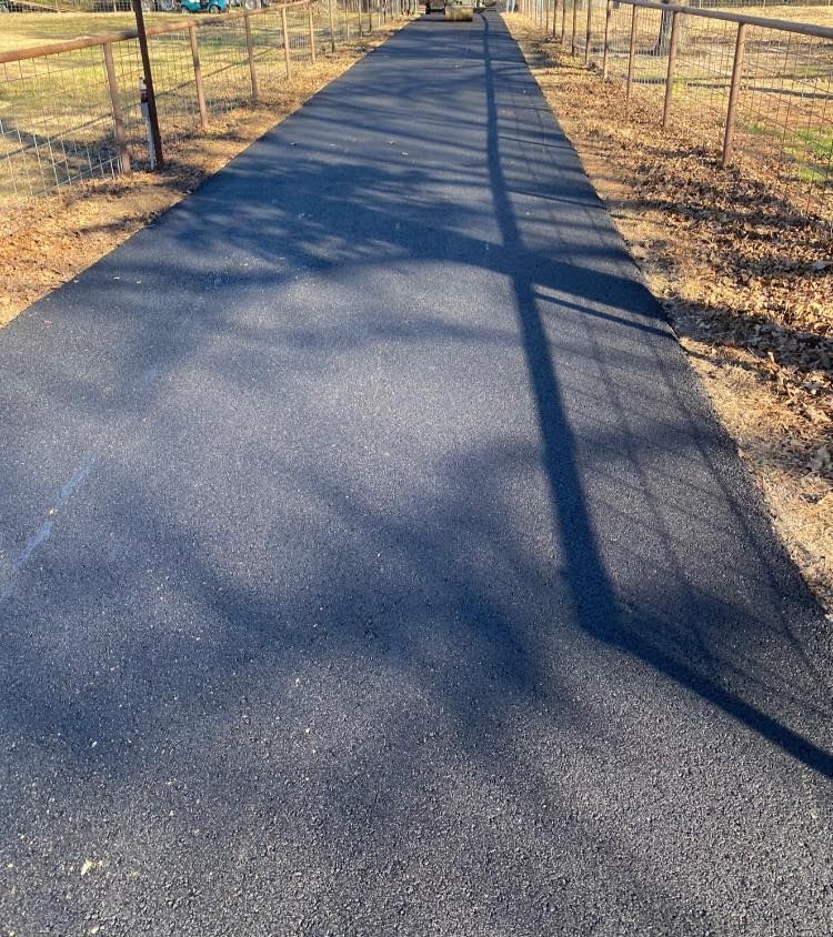 A shadow of a pole is cast on the road