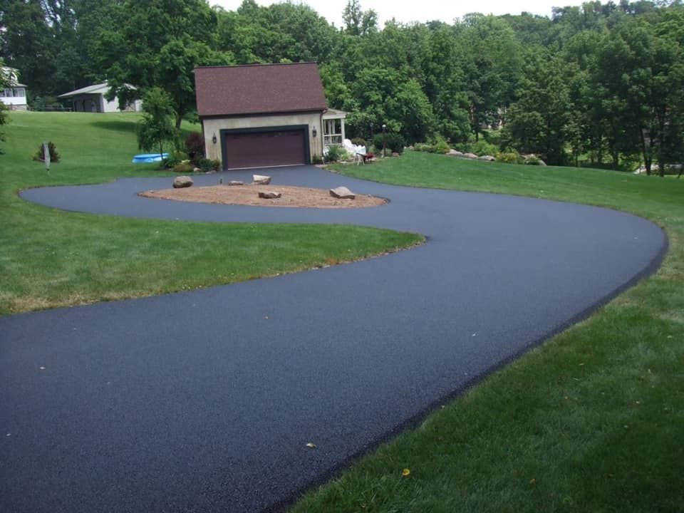 A driveway with a baseball field in the middle of it