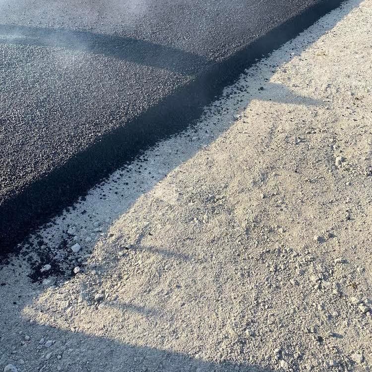 A close up of a piece of asphalt being applied to a road.
