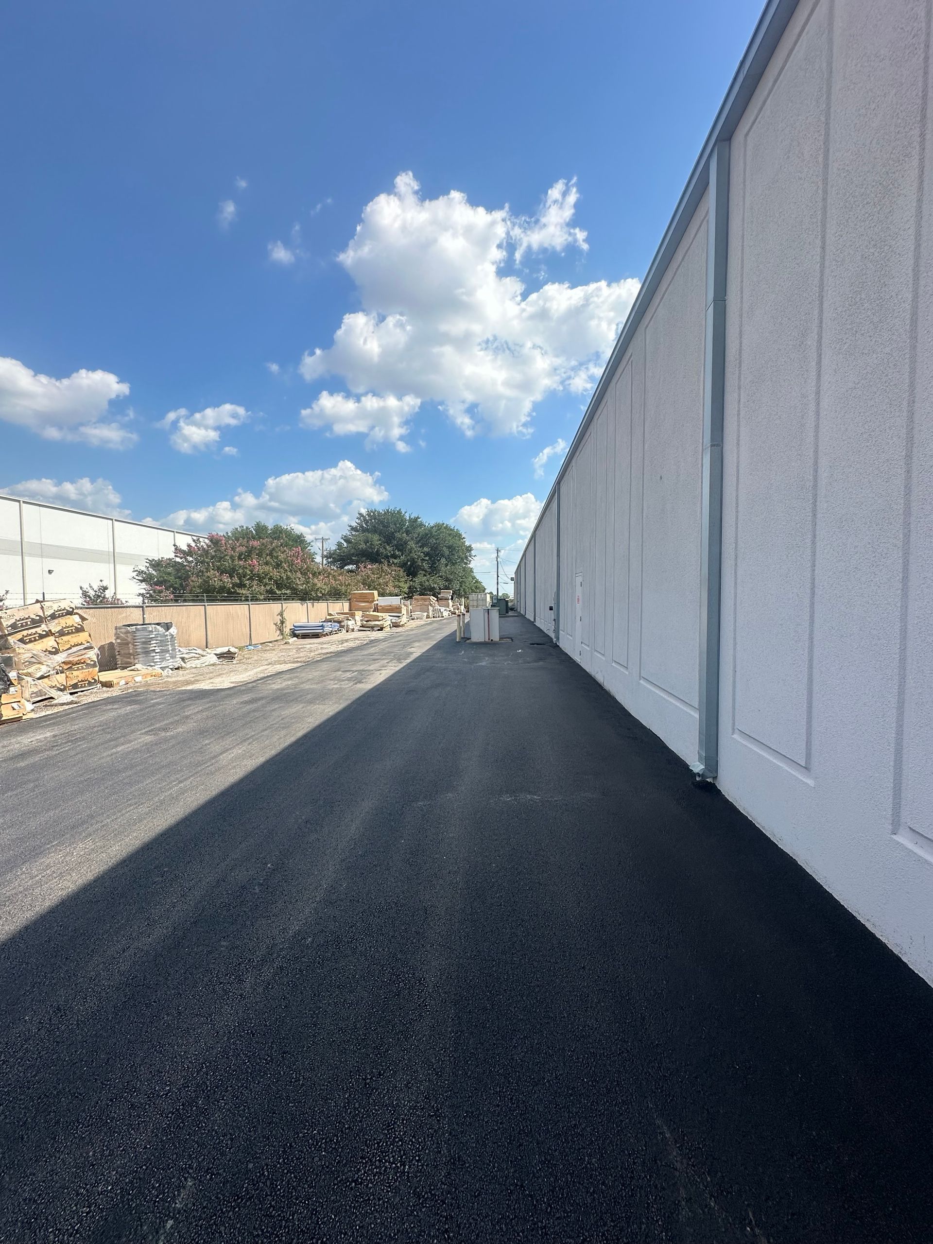 A road with a white wall on the side of it