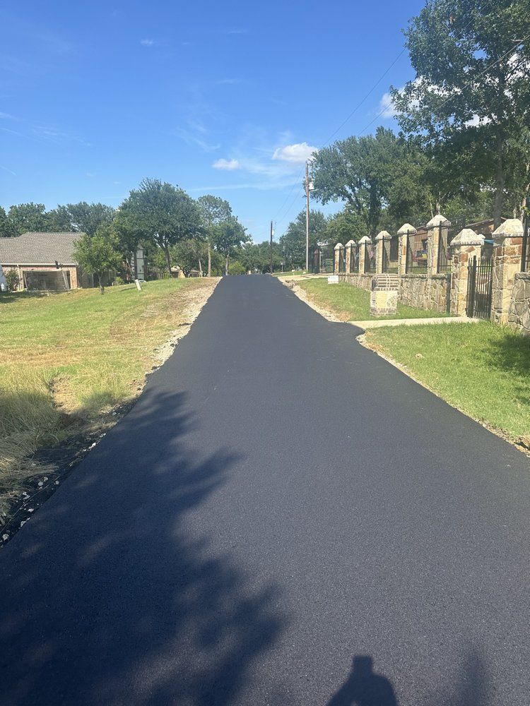 A shadow of a person is cast on the side of a road.