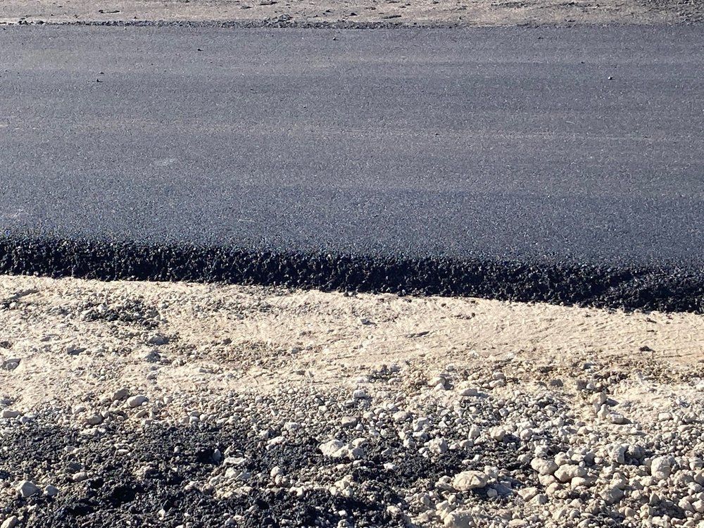 A close up of a road with gravel on the side
