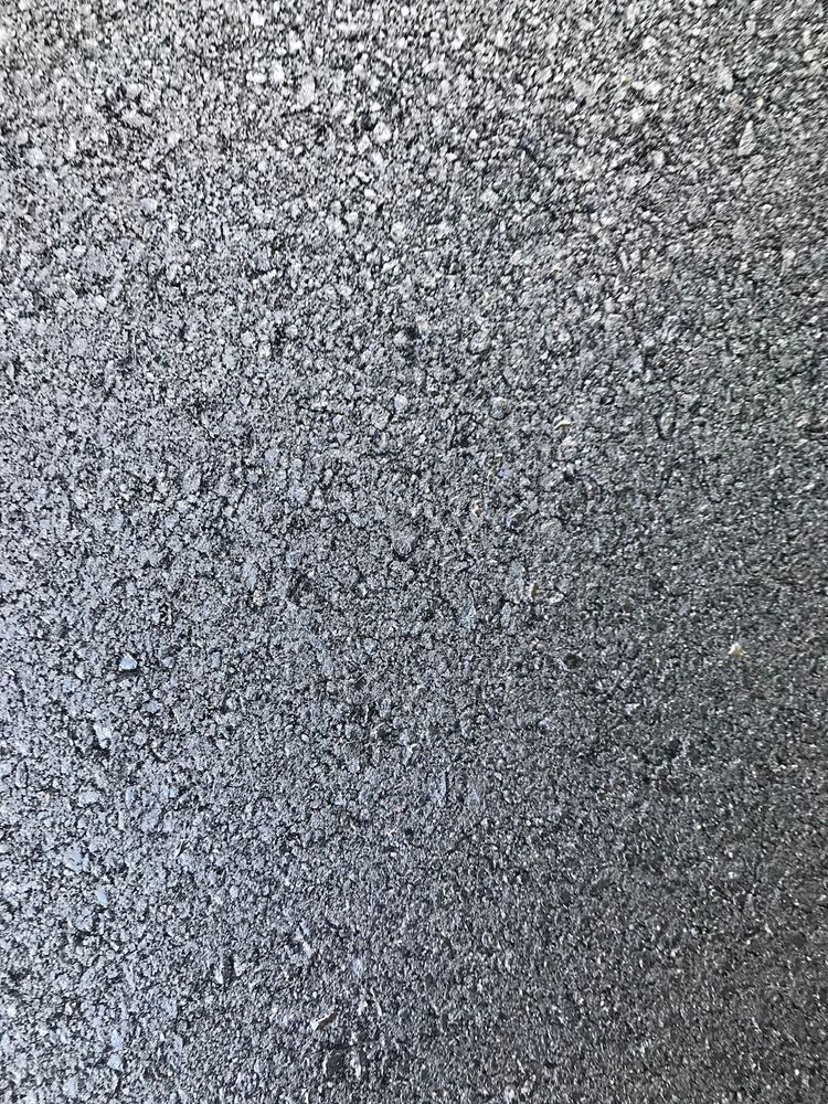 A close up of a gray surface with a lot of small stones on it.