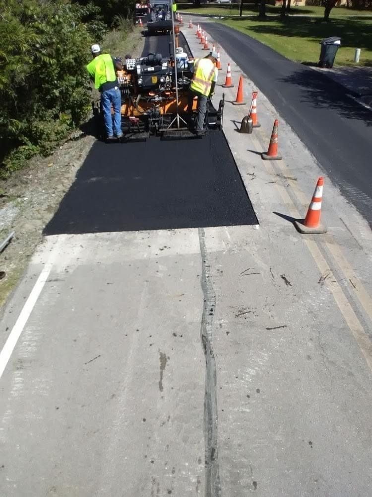 A group of construction workers are working on a road