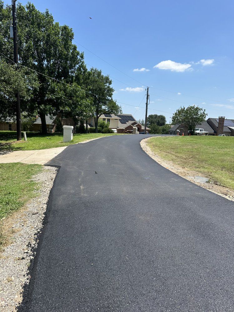 A newly paved road going through a residential area.