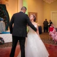 Bride and groom dancing at a wedding reception in a decorated ballroom