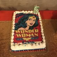 Wonder Woman birthday cake with colorful topper on a table