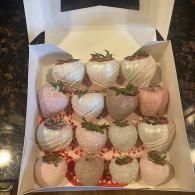 Box of chocolate-covered strawberries with white drizzle and pastel coatings in a bakery-style gift box