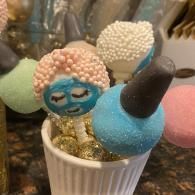 Decorated cake pop bouquet in a white cup, with colorful sprinkle-coated treats on sticks