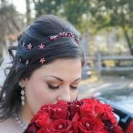 Woman with dark hair smelling a bouquet of red roses outdoors