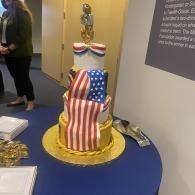 Decorated cake with U.S. flag icing on a blue table at an indoor display