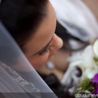 Close-up of a veiled person with closed eyes, resting beside white flowers