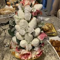 White seashell floral centerpiece with pink roses on a banquet table