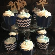 Blue and chevron cupcake display with white frosting on a tiered stand