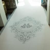 White carpet with a subtle gray ornate medallion pattern in a hallway