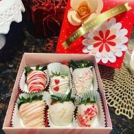 Gift box of decorated chocolate-covered treats on a festive holiday table