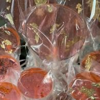 Wrapped red lollipops with clear plastic wrappers, arranged closely together.