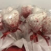 White heart-shaped balloons with red confetti and red ribbons, bundled in clear wrapping