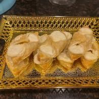 Golden tray of potato chips on a dark surface