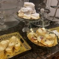 Pastries and desserts arranged on a buffet table with glass stands and gold trays